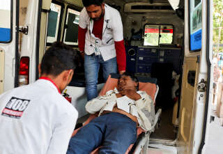 Un homme ayant subi un coup de chaleur est pris en charge par des ambulanciers, à Ahmedabad, en Inde, le 24 mai.