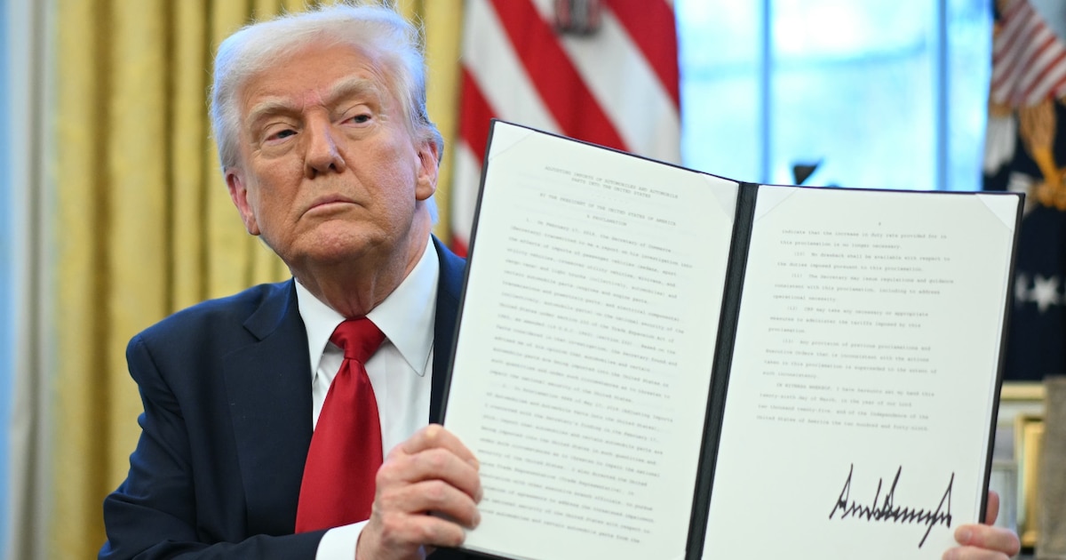 Le président américain Donald Trump montre le décret des droits de douane sur les automobiles qu'l vient de signer dans le Bureau ovale de la Maison Blanche, le 26 mars 2025 à Washington